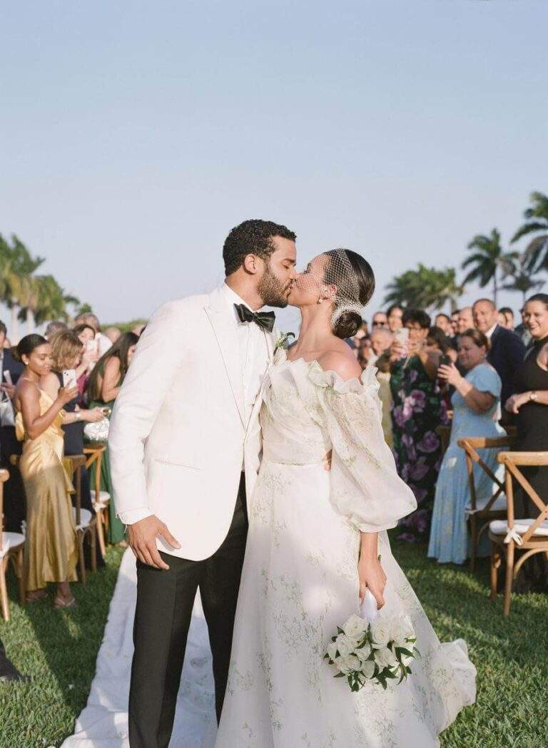 Couple kissing at the end of the aisle after their ceremony at Deering Estate's Grand Waterfront Lawn