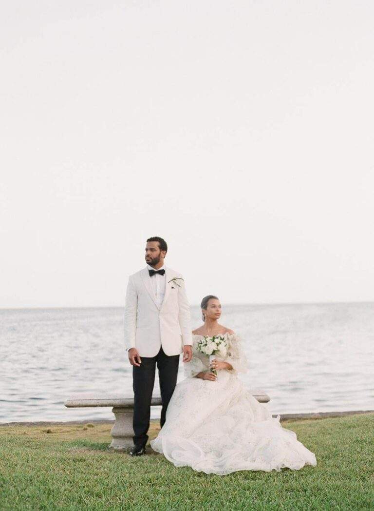 Couple at a bench at Deering Estate's Boat Basin southern finger with views of Biscayne Bay in the backdrop
