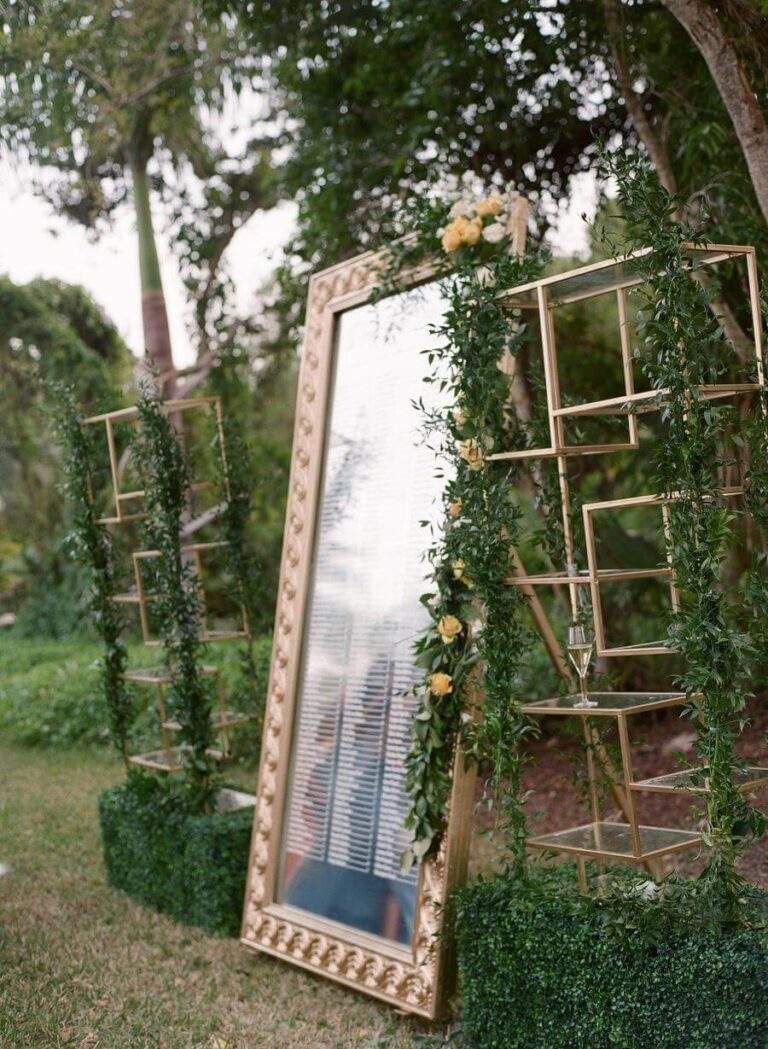 Mirrored seating chart and glass shelves at Deering Estate's Richmond Cottage Gumbo Trees set-up for cocktail-hour