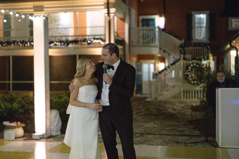 A bride and groom look lovingly at one another in front of the Richmond Cottage at their wedding.