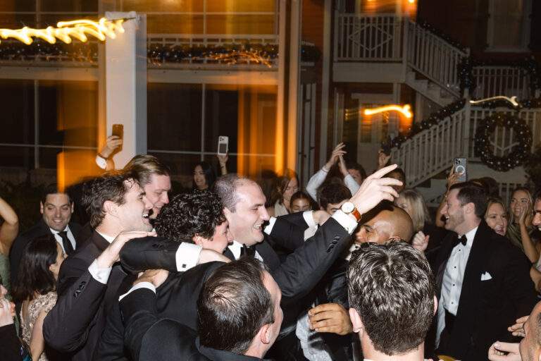 A groom and his groomsmen celebrate his wedding during the reception.