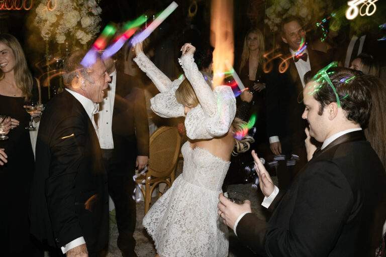 A bride and her guests dance during her wedding reception.