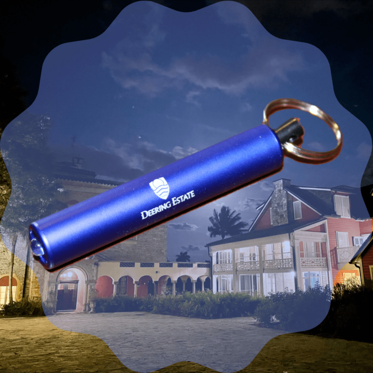 An image of a Deering Estate-branded flashlight keychain superimposed onto an image of the Stone House and Richmond Cottage.