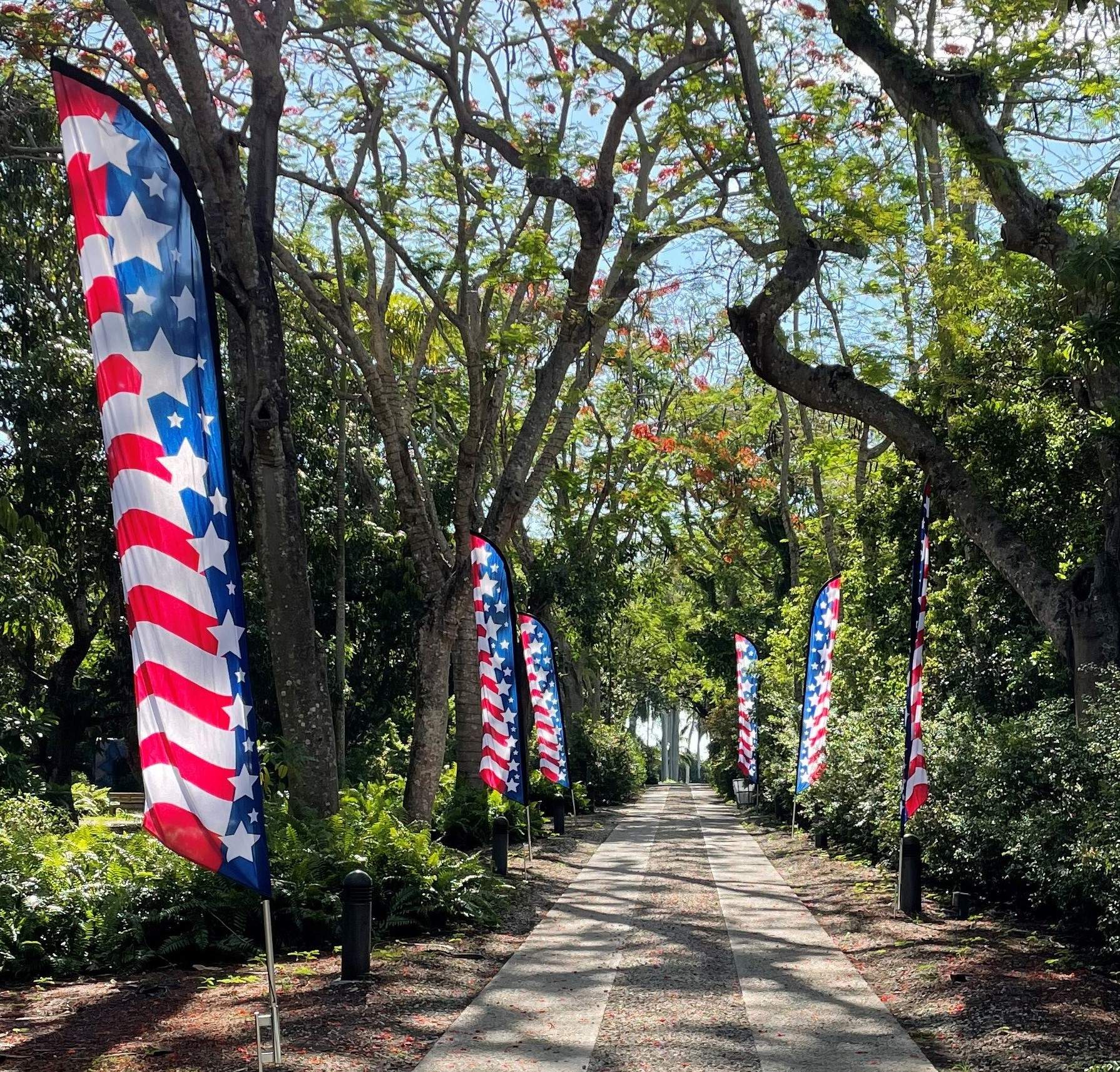 American flag banners line a path along with trees.
