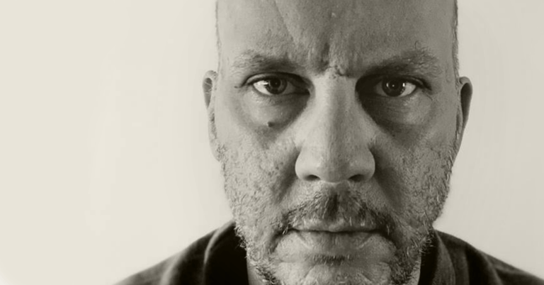 A man staring into the camera. This is artist Freddy Jouyawed.